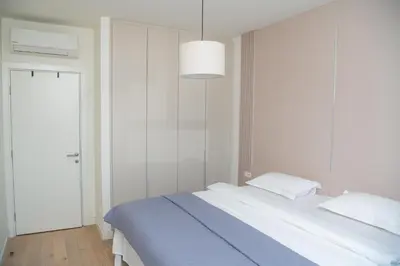 a bedroom with a large bed with a blue blanket at Belgrade Waterfront Promenade in Belgrade