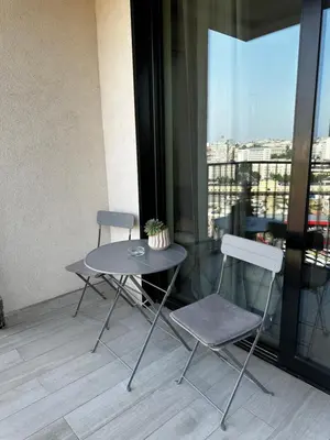 a table and two chairs in a room with a window at Belgrade Waterfront Promenade in Belgrade