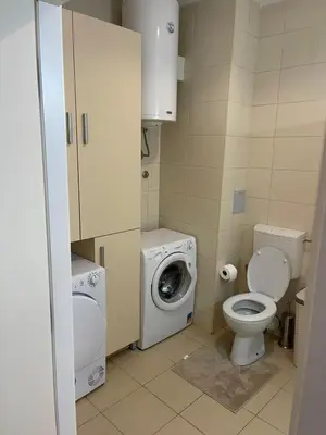 a small bathroom with a toilet and a washing machine at Neds Apt Inc in Belgrade
