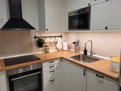 a kitchen with white cabinets and a sink at Kalemegdan Riverfront Apartment - K-District in Belgrade