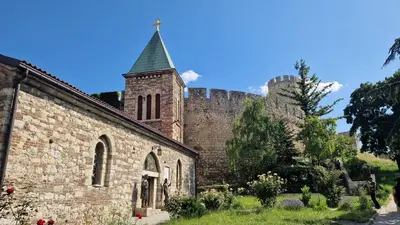 an old stone church with a tower and a castle at Kalemegdan Riverfront Apartment - K-District in Belgrade