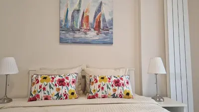 a bedroom with a bed with two lamps and a painting at Kalemegdan Riverfront Apartment - K-District in Belgrade