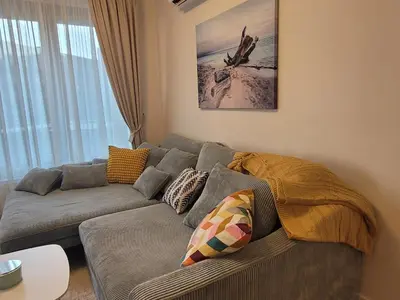 a living room with a gray couch in front of a window at Kalemegdan Riverfront Apartment - K-District in Belgrade