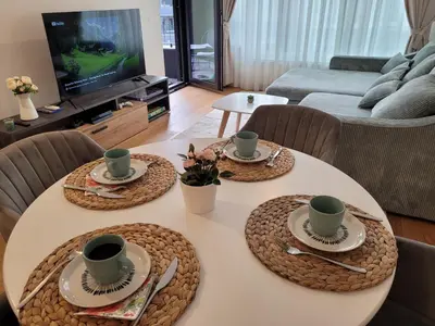 a table with three cups and plates on it in a living room at Kalemegdan Riverfront Apartment - K-District in Belgrade