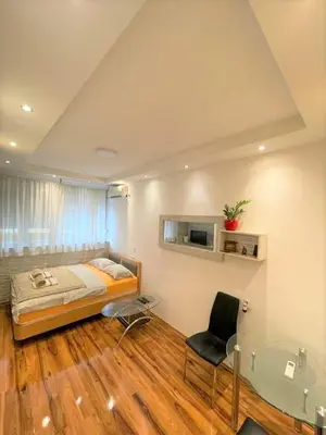 a bedroom with a bed and a glass table at Welcome To Our Easygoing Apartment in Belgrade