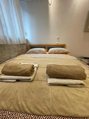 a large bed with two pillows on top of it at Welcome To Our Easygoing Apartment in Belgrade