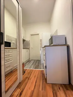 a kitchen with white appliances and a wooden floor at Welcome To Our Easygoing Apartment in Belgrade