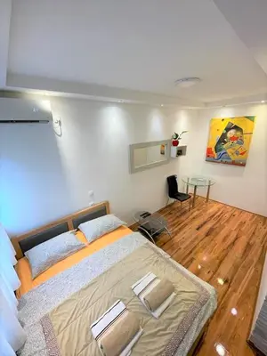 a bedroom with a large bed and a table at Welcome To Our Easygoing Apartment in Belgrade