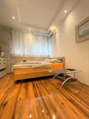 a bedroom with a bed and a table in it at Welcome To Our Easygoing Apartment in Belgrade