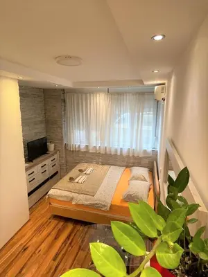 a bedroom with a bed and a television in it at Welcome To Our Easygoing Apartment in Belgrade