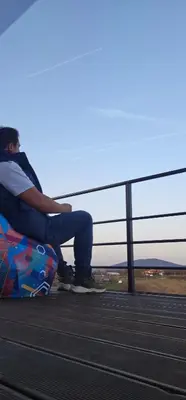 a man sitting on a bench with a skateboard at Vila Duplex in Lipovica