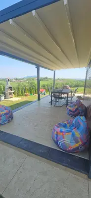a covered patio with a picnic table and a blanket at Vila Duplex in Lipovica
