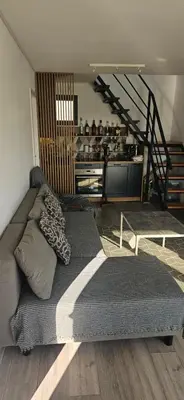 a couch in a living room with a staircase at Vila Duplex in Lipovica