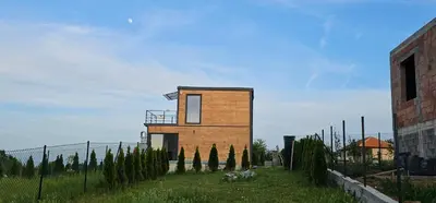 a small building in a field with a fence at Vila Duplex in Lipovica
