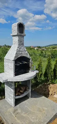 a stone pizza oven sitting on top of a field at Vila Duplex in Lipovica