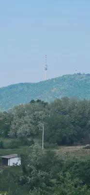 a lighthouse on top of a hill with trees at Vila Duplex in Lipovica