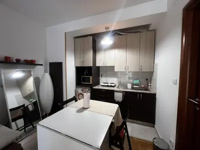 a small kitchen with a table and a white refrigerator at Family Rakic Apartment in Belgrade