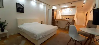 a bedroom with a bed and a table and a kitchen at Apartman Durmitor in Fontana