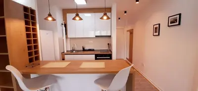 a kitchen with a wooden table and white chairs at Apartman Durmitor in Fontana