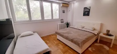 a bedroom with a bed and two windows at Apartman Durmitor in Fontana