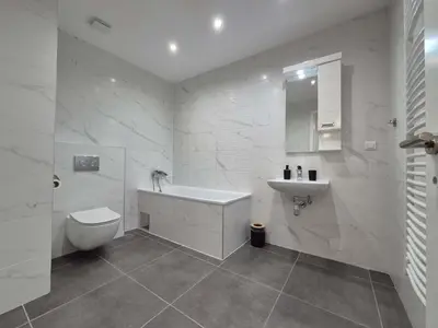 a white bathroom with a sink and a toilet at Park Vila New Luxury apartments with garage in Belgrade