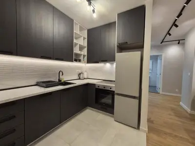 a kitchen with black cabinets and a white refrigerator at Park Vila New Luxury apartments with garage in Belgrade