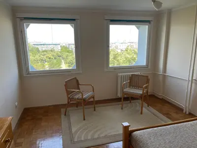 two chairs sitting in a room with two windows at Comfort & Style Panoramic Urban Retreat in Novi Beograd
