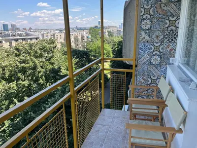 a balcony with a chair and a mosaic wall at Comfort & Style Panoramic Urban Retreat in Novi Beograd