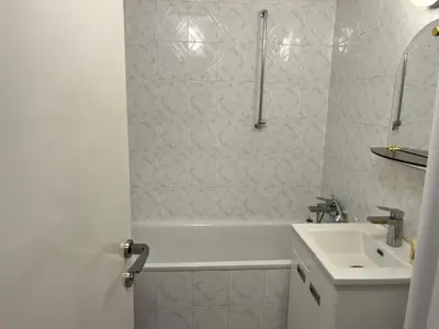 a white bathroom with a sink and a shower at Comfort & Style Panoramic Urban Retreat in Novi Beograd