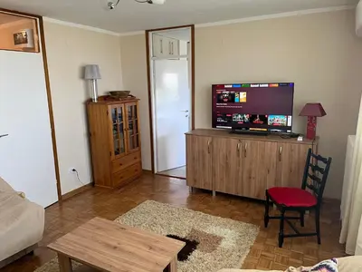 a living room with a flat screen tv on a cabinet at Comfort & Style Panoramic Urban Retreat in Novi Beograd