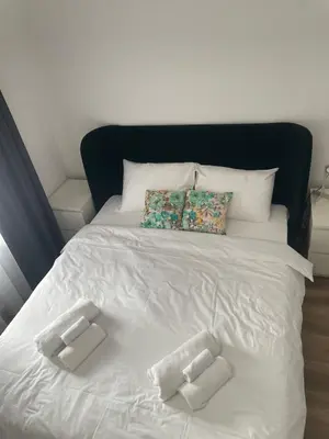 a white bed with two pillows on top of it at Apartment Magnolia gallery in Zemun