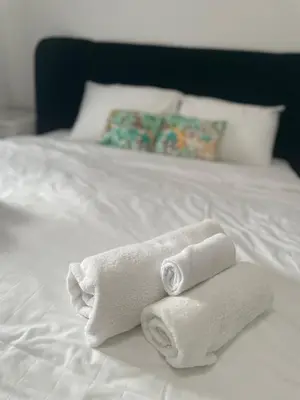 two towels sitting on top of a white bed at Apartment Magnolia gallery in Zemun