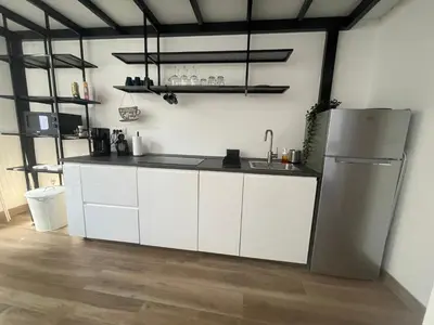 a kitchen with white cabinets and a refrigerator at Apartment Magnolia gallery in Zemun