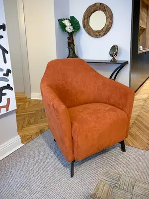 an orange chair in a living room with a mirror at Pop's Apartments in Belgrade