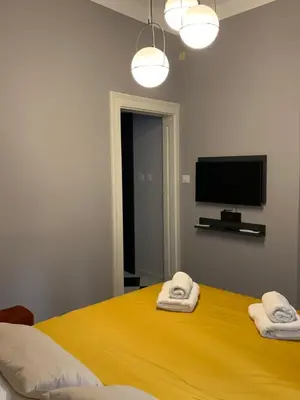 a bedroom with a yellow bed with two towels at Pop's Apartments in Belgrade