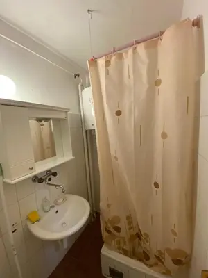 a bathroom with a shower curtain and a sink at Stay4day in Kijevo