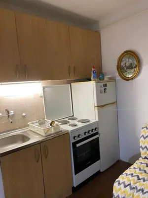 a small kitchen with a stove and a refrigerator at Stay4day in Kijevo