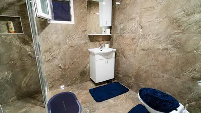 a bathroom with a shower with a toilet and a sink at Skyline Suites Belgrade in Ledine