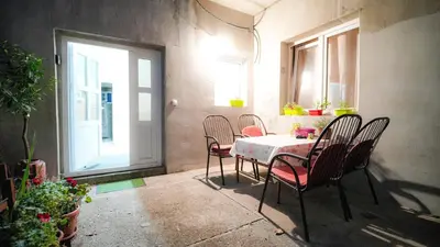 a dining room with a table and chairs and a window at Skyline Suites Belgrade in Ledine
