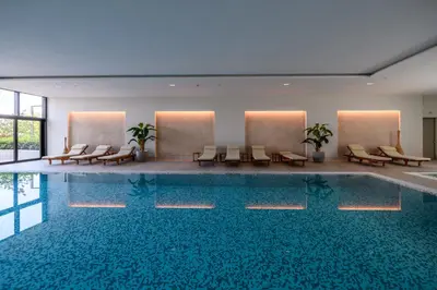 a pool in a hotel with chairs and tables at Luxury apartment with Pool&Gym in Belgrade