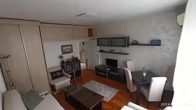 a living room with a table and a dining room at Stan na dan Beograd in Karaburma