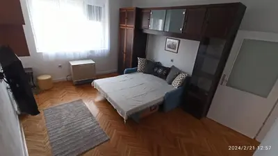 a small bedroom with a bed and a window at Stan na dan Beograd in Karaburma