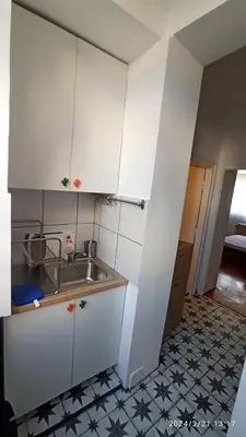 a kitchen with white cabinets and a sink at Stan na dan Beograd in Karaburma