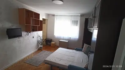 a small living room with a couch and a window at Stan na dan Beograd in Karaburma