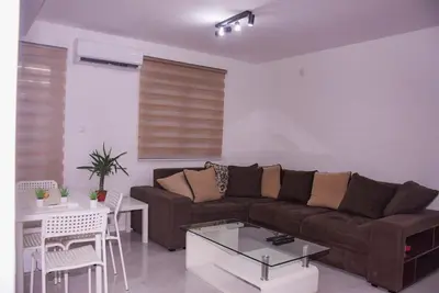a living room with a brown couch and a table at Marash apartman - stan na dan in Belgrade