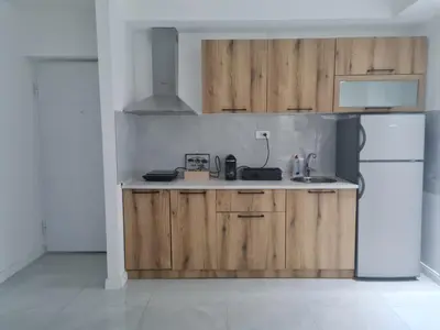 a kitchen with wooden cabinets and a white refrigerator at Marash apartman - stan na dan in Belgrade