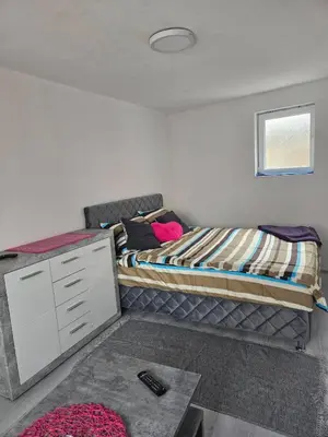 a bedroom with a bed and a dresser in it at MM apartman in Mladenovac