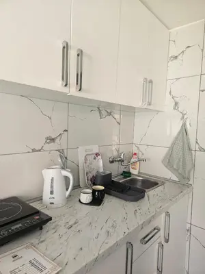 a kitchen with white cabinets and a counter top at MM apartman in Mladenovac