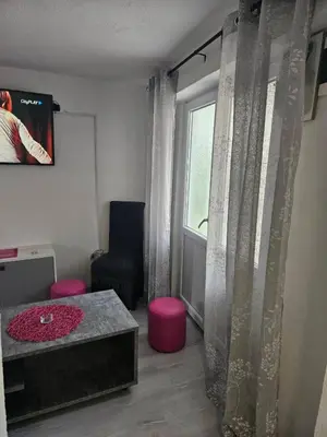 a living room with a table and a window at MM apartman in Mladenovac