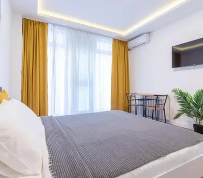 a bedroom with a large bed with yellow curtains at yubc in Novi Beograd